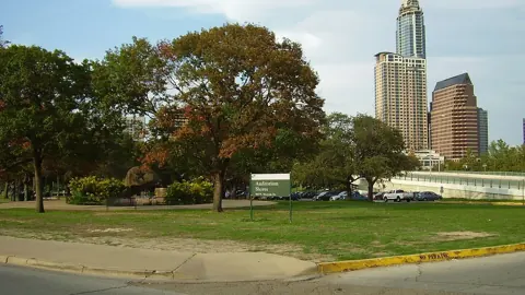 Auditorium Shores lawn on Lady Bird Lake with the Austin skyline behind